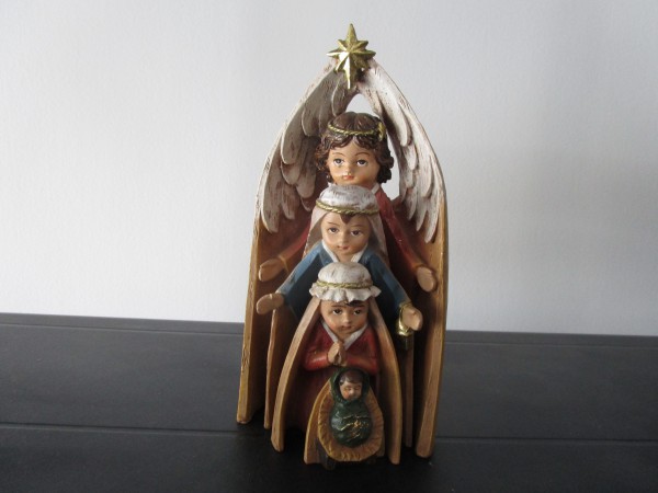 Joseph, Mary and Jesus are ''nested'' between the angel's wings
